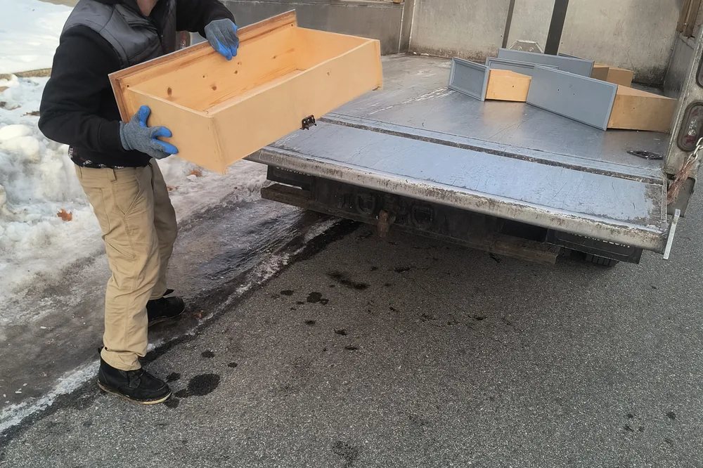 DrouCo crew member carrying furniture out on a Southern NH job